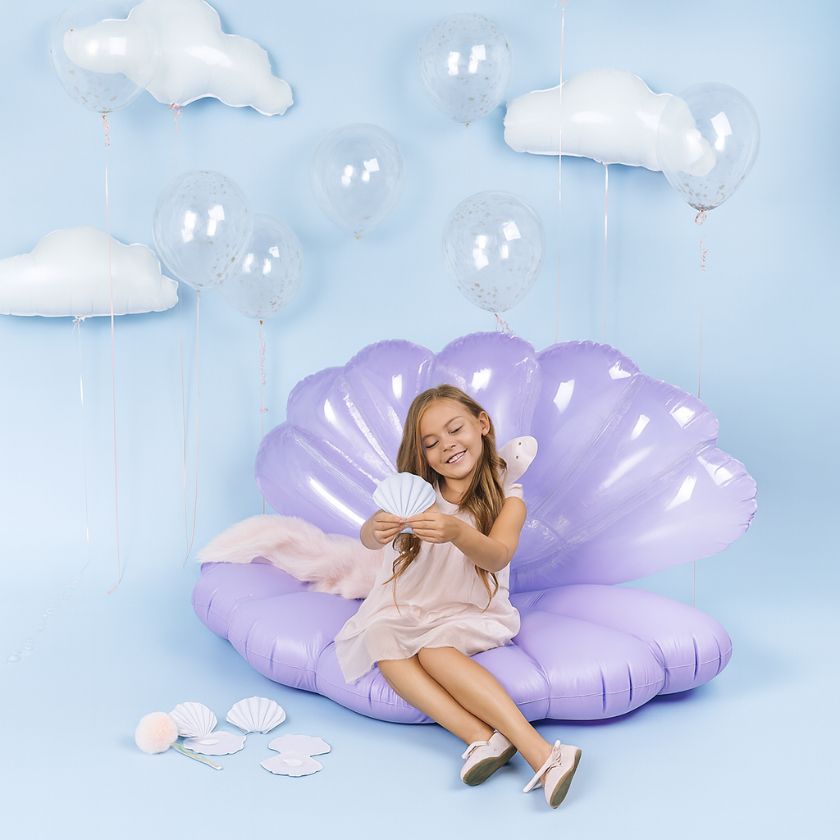 Child sitting on a purple shell-shaped inflatable chair with seashell invitation