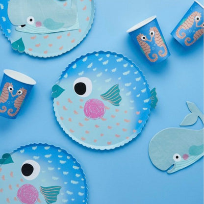 Children's party tableware with fish and seahorse designs on a blue background