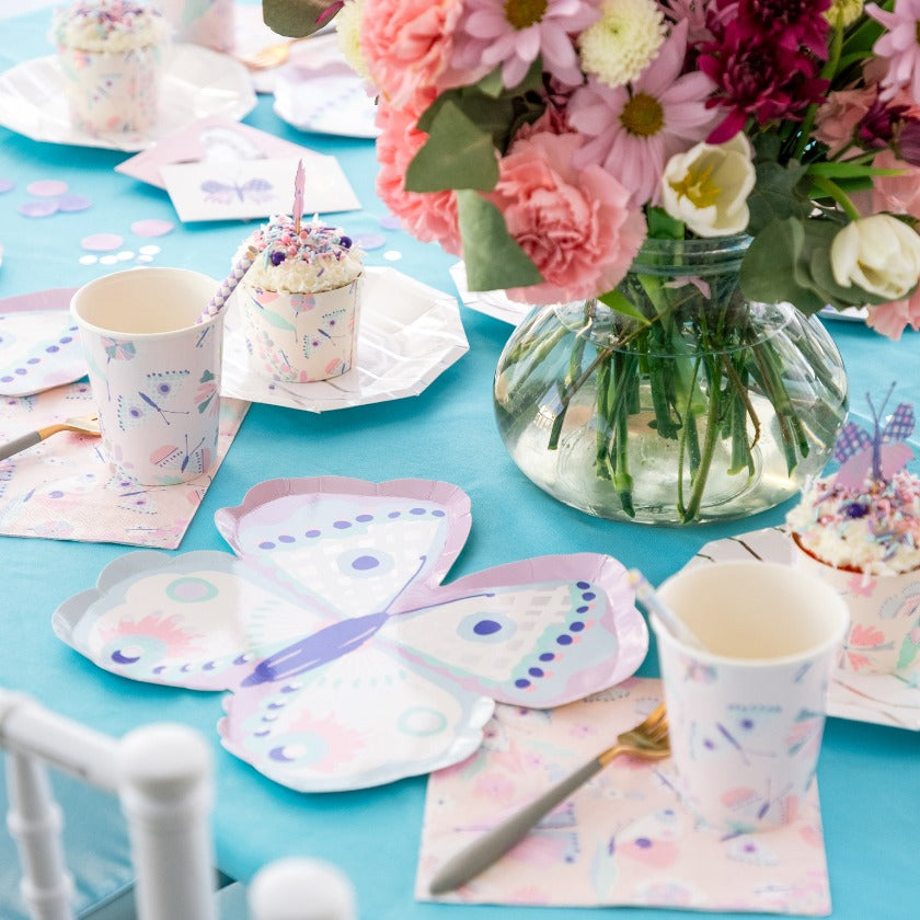 Beautiful tablescape with lilac butterfly shaped plates,cups,flowers and napkins