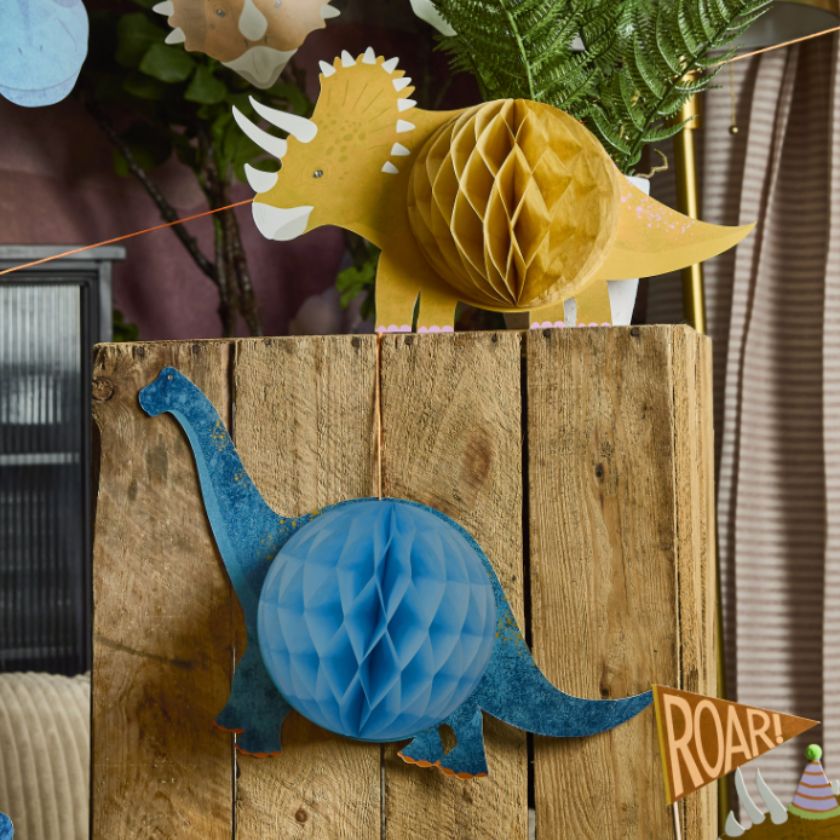 Decorative paper dinosaurs on a wooden block with a 'Roar!' sign.