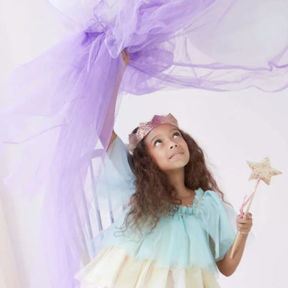 Beautiful soft image of girl with lilac flowing organza fabric holding a Meri Meri Pink And gold wand