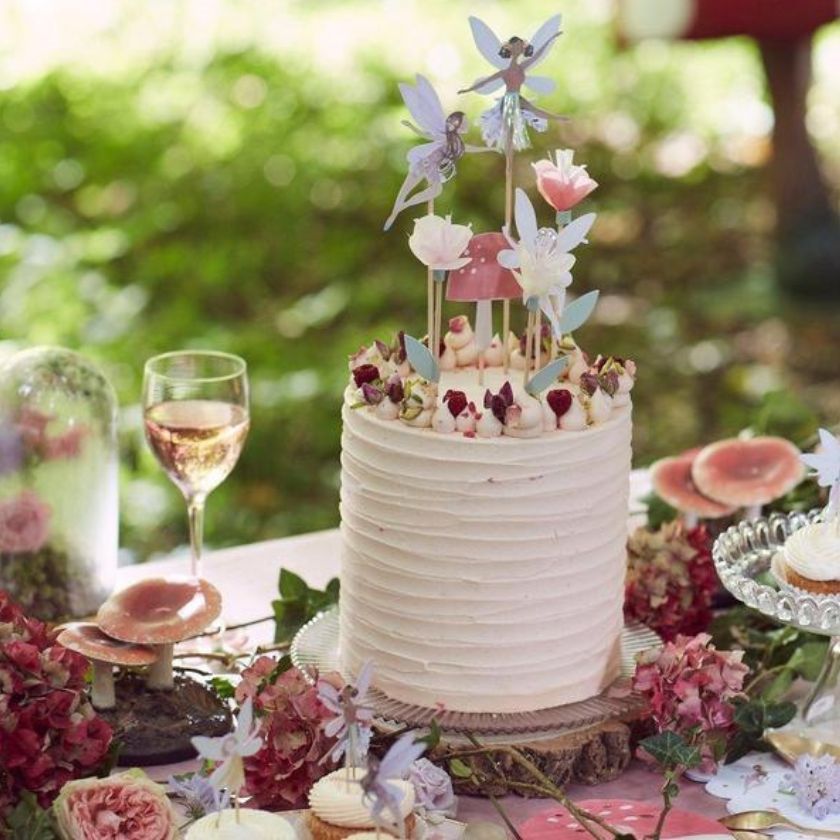 Beautiful Fairy Party Table with cake with fairy toppers, toadstools and flowers