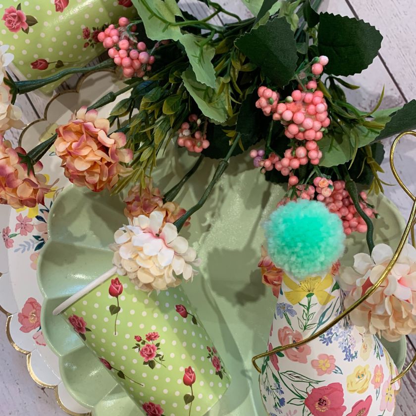 Vintage inspired Table setting with green floral cups, vintage party hats and vintage plates