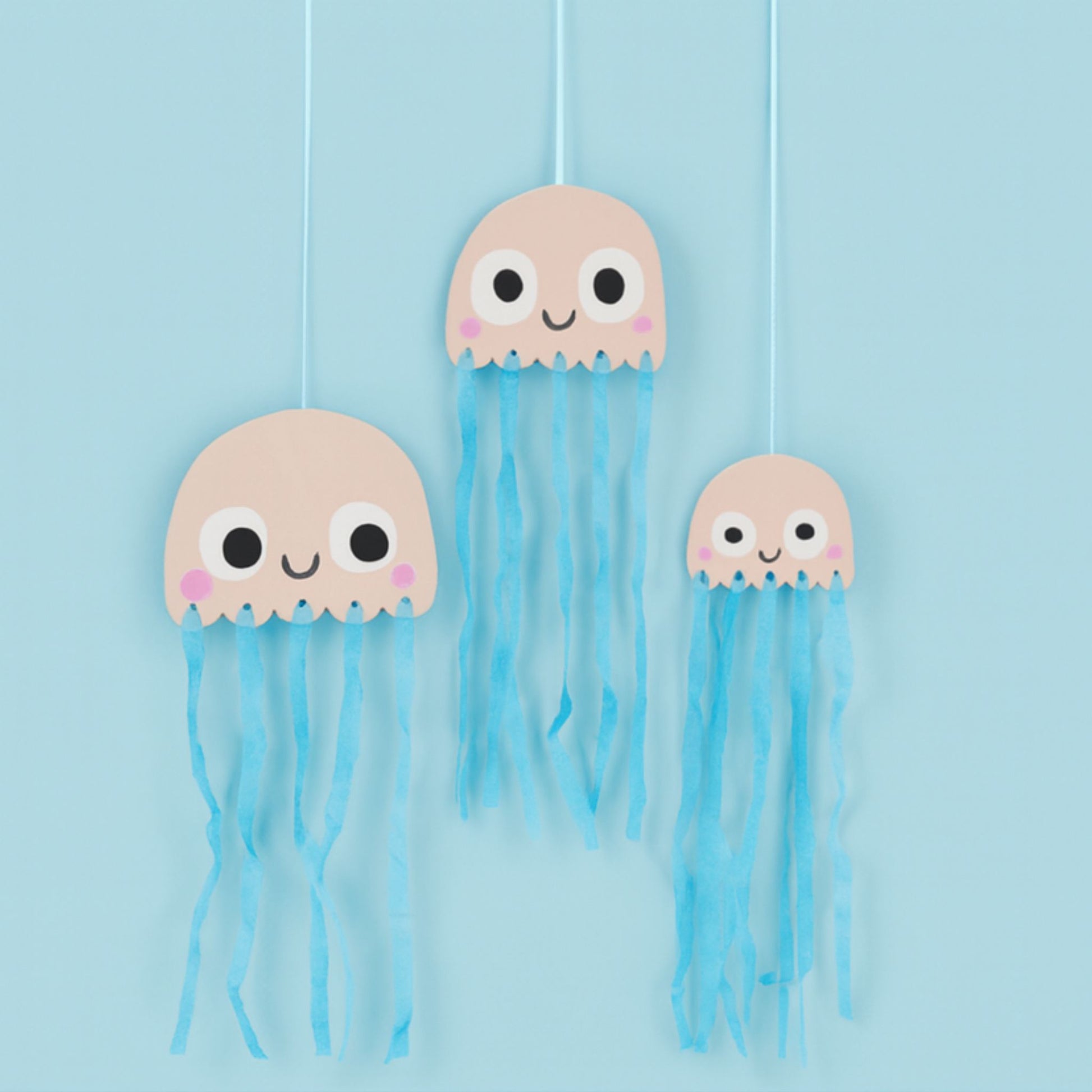 Three paper jellyfish decorations with blue tissue tantacals
