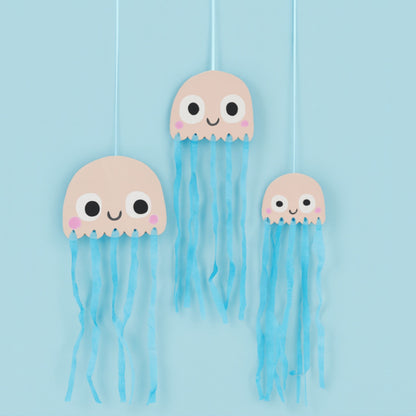 Three paper jellyfish decorations with blue tissue tantacals
