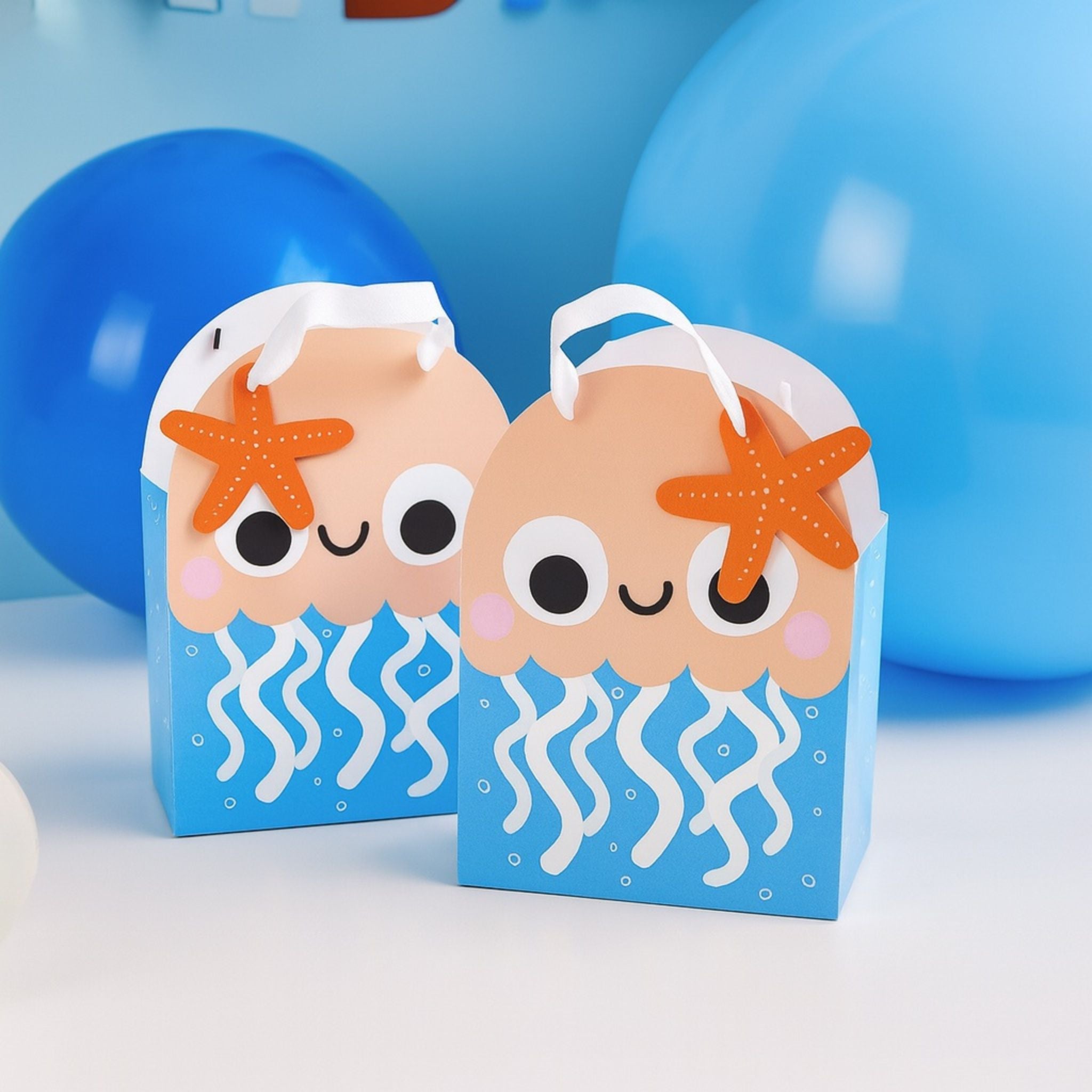 Jellyfish party bags on blue background with orange starfish gift tag and white handles