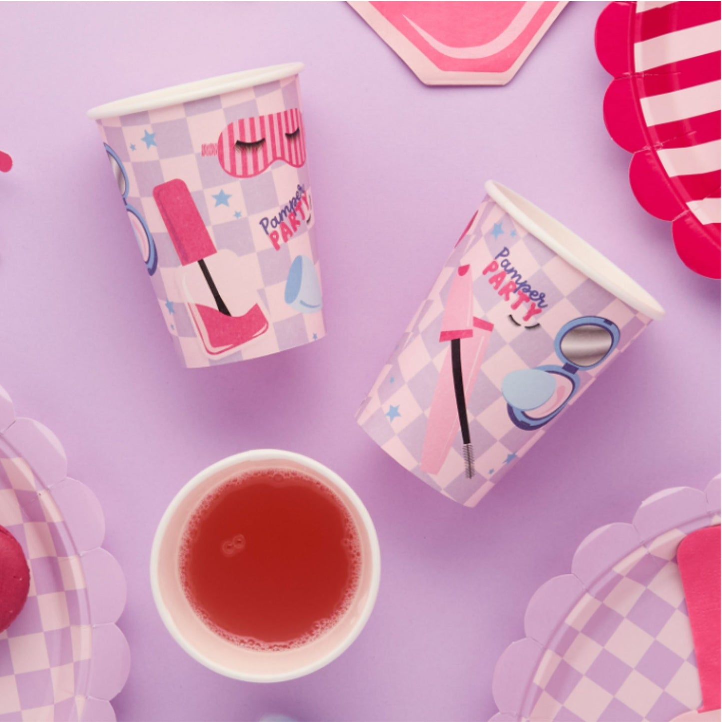 Party cups with cosmetic-themed design on a purple background