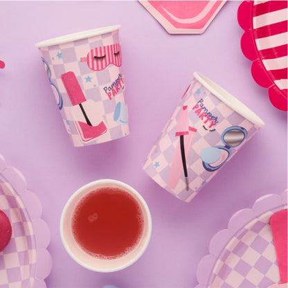 Party cups with cosmetic-themed design on a purple background