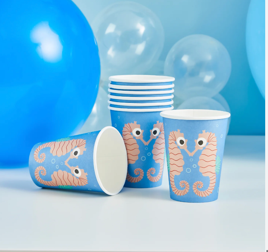 Set of paper cups with seahorse design on a light blue background
