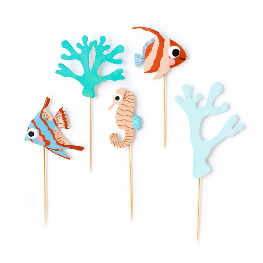 Set of ocean-themed cake toppers including fish, seahorse, and coral on wooden picks