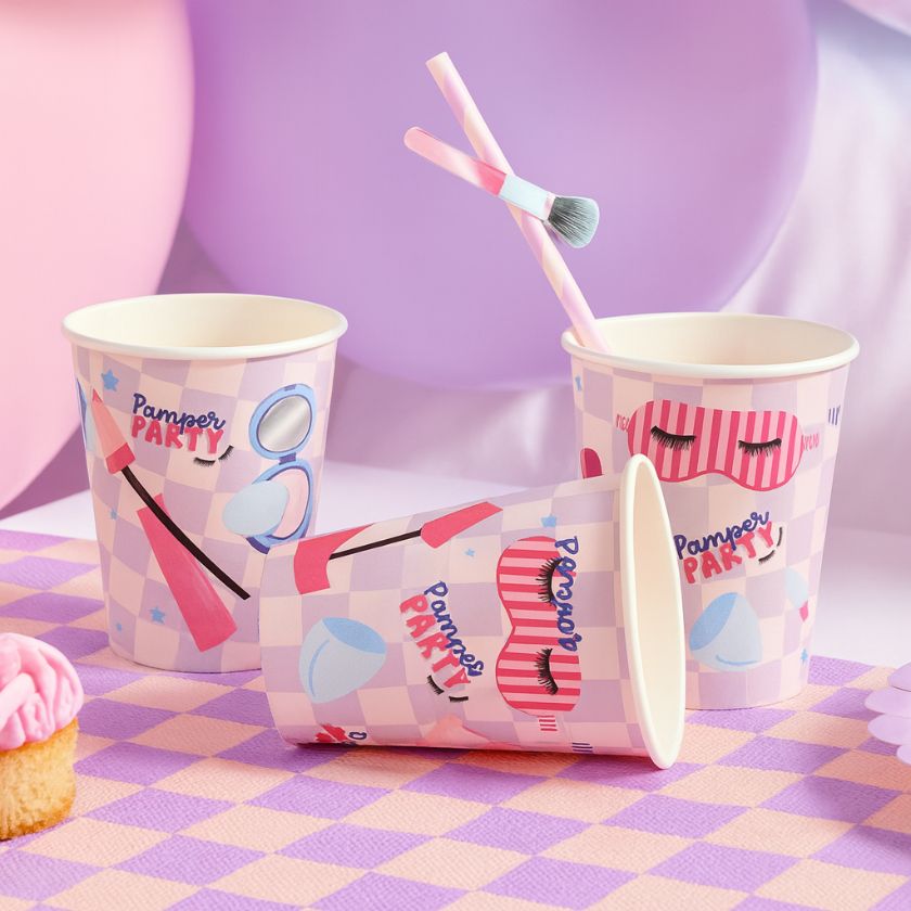 Paper cups with cosmetic-themed design on a checkered tablecloth