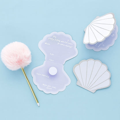Seashell-shaped party invitations with glitter edges